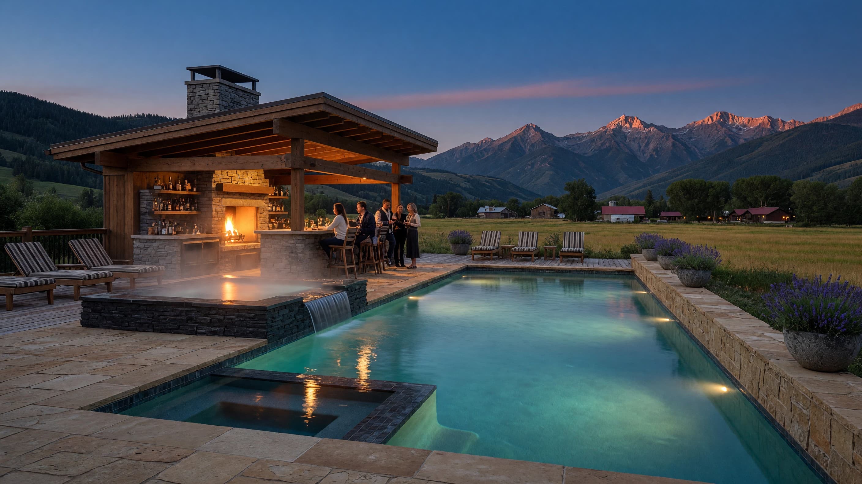 The Herrington's heated pool at blue hour — steam rising off the spa beside the fire-lit bar pavilion, alpenglow on the peaks beyond